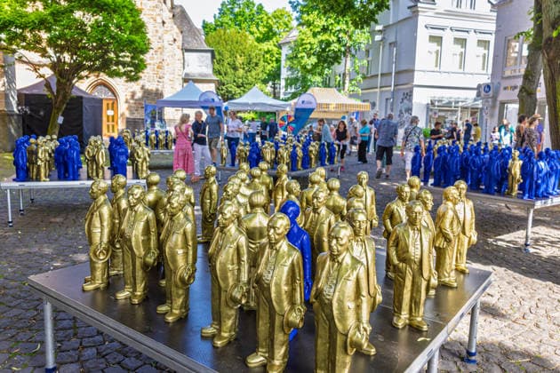 Adenauer-Kunstinstallation in Bad Honnef - 23.05.26. Kunstinstallation des Künstlers Ottmar Hörl mit 200 goldenen und blauen Skulpturen des ersten Bundeskanzlers Konrad Adenauer auf dem Kirchplatz in Bad Honnef. Die Präsentation fand anlässlich des 150. Geburtstags Adenauers statt und war Teil eines Rahmenprogramms mit Straßenmusikfestival in der Innenstadt. Gemeinschaftsprojekt der Stiftung Bundeskanzler-Adenauer-Haus, der Konrad-Adenauer-Stiftung und der Stadt Bad Honnef. Bad Honnef Nordrhein-Westfalen Deutschland *** Adenauer art installation in Bad Honnef 23 05 26 Art installation by artist Ottmar Hörl with 200 gold and blue sculptures of the first Federal Chancellor Konrad Adenauer on the church square in Bad Honnef The presentat Copyright: xMarcxJohnx