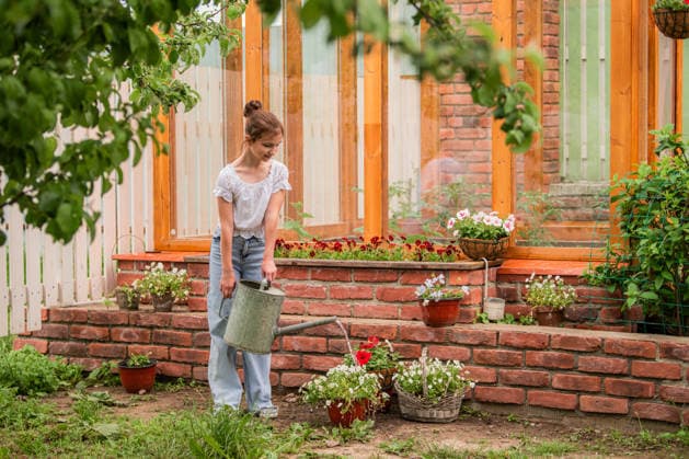 Ein junges Mädchen gießt Pflanzen im Garten. A young girl is watering plants in a garden. She is wearing a white shirt and blue jeans (License=RF) ,model released, Symbolfoto Copyright: xZoonar.com MARIA_MOROZx 25057191 ,model released, Symbolfoto ,property released