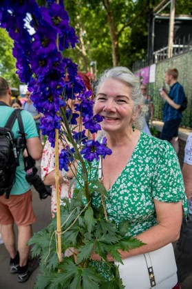 May 23, 2026, London, United Kingdom: A visitor to the last day of the RHS Chelsea Flower Show stands holding a purple flowering plant. Members of the public leave the Chelsea Flower Show carrying flowers, plants, and garden ornaments purchased from the exhibition displays on the event™s final day. As the famous horticultural showcase drew to a close, visitors were seen transporting blooms, shrubs and decorative items through the streets of Chelsea after buying pieces from the award-winning gardens and floral exhibits. London United Kingdom - ZUMAs197 20260523_aaa_s197_516 Copyright: xJamesxWilloughbyx