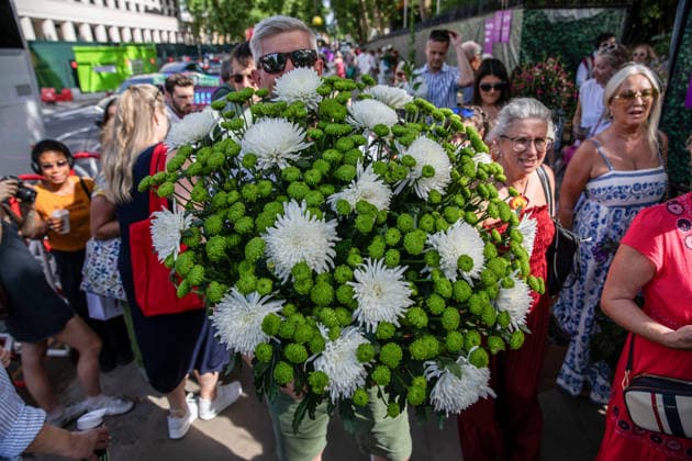 May 23, 2026, London, United Kingdom: A visitor to the last day of the RHS Chelsea Flower Show stands holding a large flower display. Members of the public leave the Chelsea Flower Show carrying flowers, plants, and garden ornaments purchased from the exhibition displays on the event™s final day. As the famous horticultural showcase drew to a close, visitors were seen transporting blooms, shrubs and decorative items through the streets of Chelsea after buying pieces from the award-winning gardens and floral exhibits. London United Kingdom - ZUMAs197 20260523_aaa_s197_505 Copyright: xJamesxWilloughbyx