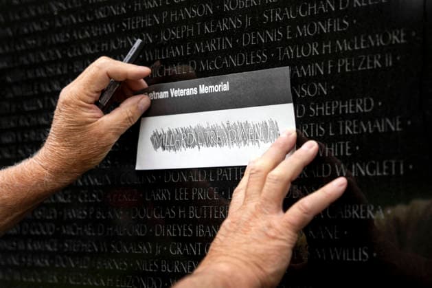 News Bilder des Tages A volunteer etches a name onto paper at the Vietnam Veterans Memorial on Memorial Day in Washington, DC on Monday, May 25, 2026.  WAP20260525307 BONNIExCASH