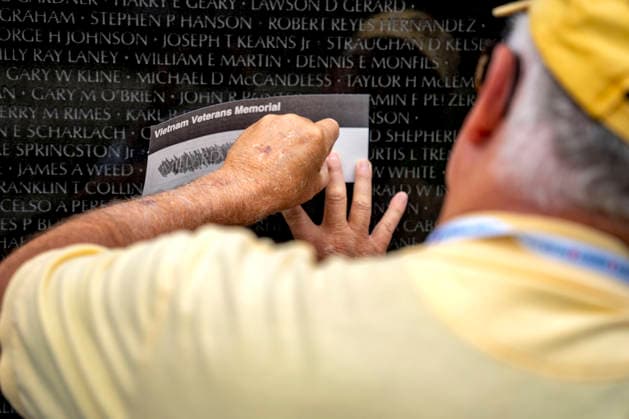A volunteer etches a name onto paper at the Vietnam Veterans Memorial on Memorial Day in Washington, DC on Monday, May 25, 2026.  WAP20260525306 BONNIExCASH