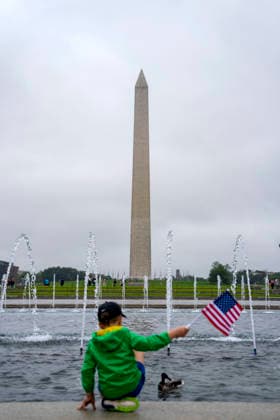 A child waves a U.S. Flag at the World War II Memorial on Memorial Day in Washington, DC on Monday, May 25, 2026.  WAP20260525321 BONNIExCASH