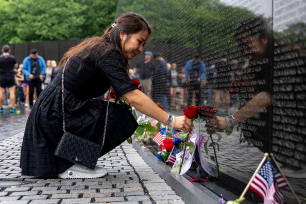 A woman leaves roses at the Vietnam Veterans Memorial on Memorial Day in Washington, DC on Monday, May 25, 2026.  WAP20260525323 BONNIExCASH