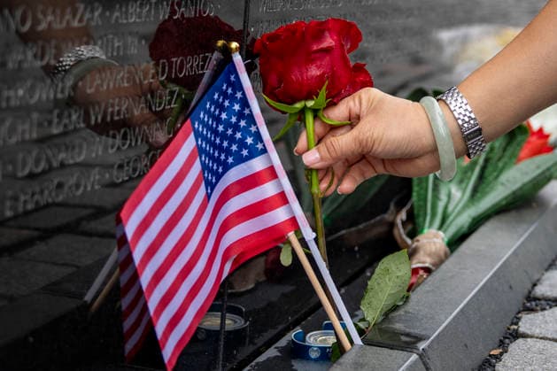 A woman leaves roses at the Vietnam Veterans Memorial on Memorial Day in Washington, DC on Monday, May 25, 2026.  WAP20260525324 BONNIExCASH
