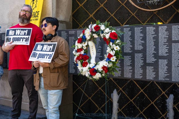 May 25, 2026, Chicago, Illinois, USA: Two protesters in front of the wall of the fallen at the Vietnam Memorial Fountain on Chicago s Riverfront on Memorial Day to protest continued US wars, and organized by About Face Chicago USA - ZUMAr170 20260525_znp_r170_003 Copyright: xChrisxRihax