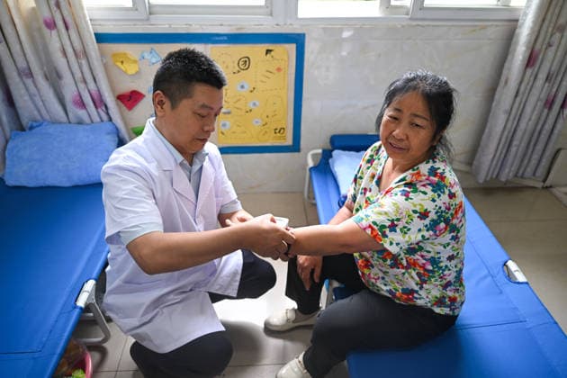 CHONGQING, CHINA - MAY 25: A medical worker checks the health status of a disaster-affected resident at a resettlement site set up in a school after a heavy rainstorm hit Yongchuan District on May 25, 2026 in Chongqing, China. Local authorities have set up 42 centralized shelters accommodating over 2,100 people following flash floods and geological disasters triggered by extreme rainstorms that hit Yongchuan District from the night of May 23 to the early hours of May 24.  Copyright: xChinaxNewsxServicex 111643998140