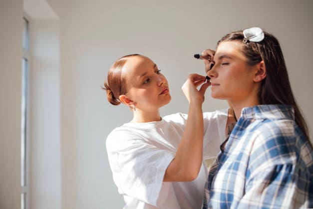 Eine Visagistin schminkt eine Frau in einem hellen, modernen Studio und demonstriert dabei in einer professionellen Umgebung mit natürlichem Licht ihre Schönheitstechniken und ihr künstlerisches Können Makeup artist skillfully applies cosmetics to a model in a contemporary studio, highlighting beauty techniques and artistry in a well-lit environment (License=RF) ,model released, Symbolfoto Copyright: xZoonar.com DashaxPetrenkox 25102995 ,model released, Symbolfoto ,property released