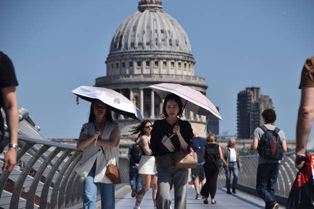 May 26, 2026, London, England, United Kingdom: People shelter from the scorching sun under umbrellas on Millennium Bridge with a view of St Paul s Cathedral as temperatures soar in the capital. The UK recorded its hottest ever day in May yesterday. London United Kingdom - ZUMAv130 20260526_zip_v130_002 Copyright: xVukxValcicx