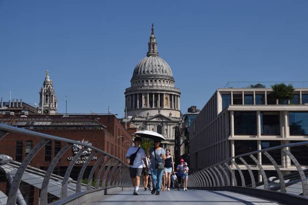 May 26, 2026, London, England, United Kingdom: People shelter from the scorching sun under an umbrella on Millennium Bridge with a view of St Paul s Cathedral as temperatures soar in the capital. The UK recorded its hottest ever day in May yesterday. London United Kingdom - ZUMAv130 20260526_zip_v130_001 Copyright: xVukxValcicx