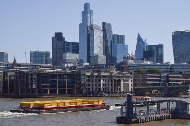 May 26, 2026, London, England, United Kingdom: A boat pulling containers passes by the City of London skyline, the capital s financial district. London United Kingdom - ZUMAv130 20260526_zip_v130_007 Copyright: xVukxValcicx
