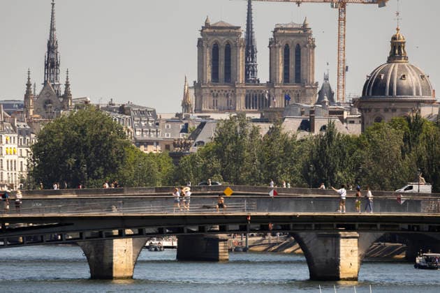 Paris, France May 27, 2026 - People walk across a bridge over the Seine near Notre Dame de Paris during a heat wave. Temperatures in the French capital are about 10 degrees higher than the seasonal average, with temperatures exceeding 30 degrees, reaching the threshold for a heat wave. METEO, CANICULE, FORTES CHALEURS, ILLUSTRATION, ESTIVAL, ESTIVALE, GENERIQUE, SOLEIL, TOURISME, SITE TOURISTIQUE, PARIS, VIGILANCE, VAGUE DE CHALEUR, CHANGEMENT CLIMATIQUE, NOTRE  Copyright: xVincentxIsorex