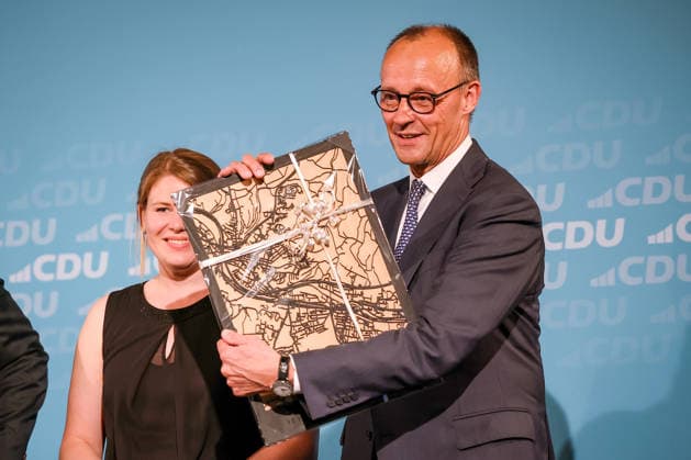 27.05.2026, Politik, Bundeskanzler Friedrich Merz (CDU) bekommt ein Geschenk - das Stadtblid - zu Gast als Festredner beim Festakt in der Schützenhalle Hüsten bei Arnsberg. 80 Jahre Neheim-Hüstener Programm. Nordrhein-Westfalen Deutschland *** 27 05 2026, Politics, Federal Chancellor Friedrich Merz CDU receives a gift the Stadtblid as guest speaker at the ceremony in the Schützenhalle Hüsten near Arnsberg 80 years of Neheim Hüstener program North Rhine-Westphalia Germany