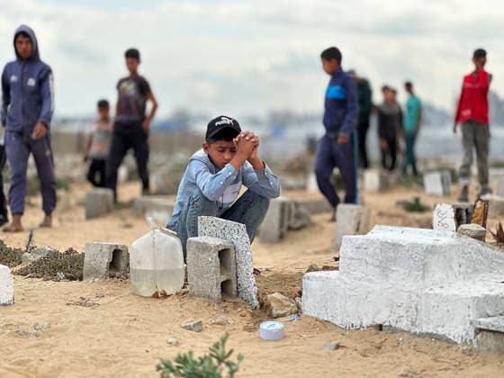 Eid Al Adha Cemetery Memorial Khan Yunis A boy sits with clasped hands next to a grave to offer prayers during Eid al-Adha at a cemetery in Khan Yunis, Gaza Strip, on May 27, 2026. Eid al-Adha, or the Feast of Sacrifice, is one of the most important holidays in the Islamic calendar, commemorating the willingness of Prophet Ibrahim to sacrifice his son. The event is traditionally marked worldwide by communal prayers, family gatherings, acts of charity, and the slaughtering of livestock. In Gaza, the ongoing conflict has significantly impacted traditional observances, leading to residents substituting fresh livestock with frozen meat and visiting the graves of those killed during the war. Khan Yunis Gaza Strip Palestinian Territories Copyright: xDoaaxAlbazx