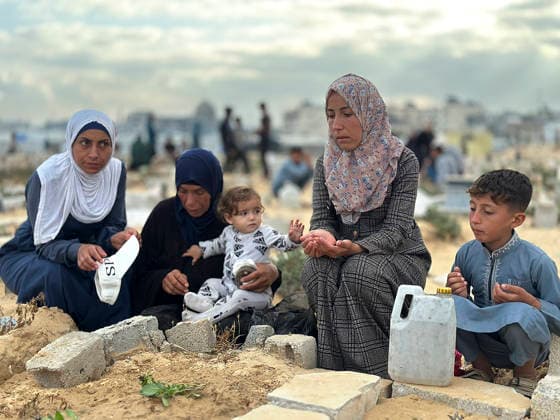 Eid Al Adha Cemetery Memorial Khan Yunis People gather next to a grave to offer prayers during Eid al-Adha at a cemetery in Khan Yunis, Gaza Strip, on May 27, 2026. Eid al-Adha, or the Feast of Sacrifice, is one of the most important holidays in the Islamic calendar, commemorating the willingness of Prophet Ibrahim to sacrifice his son. The event is traditionally marked worldwide by communal prayers, family gatherings, acts of charity, and the slaughtering of livestock. In Gaza, the ongoing conflict has significantly impacted traditional observances, leading to residents substituting fresh livestock with frozen meat and visiting the graves of those killed during the war. Khan Yunis Gaza Strip Palestinian Territories Copyright: xDoaaxAlbazx