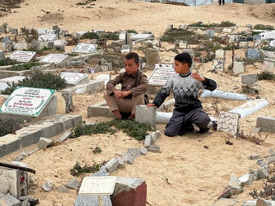Eid Al Adha Cemetery Memorial Khan Yunis Two boys sit next to a grave during Eid al-Adha at a cemetery in Khan Yunis, Gaza Strip, on May 27, 2026. Eid al-Adha, or the Feast of Sacrifice, is one of the most important holidays in the Islamic calendar, commemorating the willingness of Prophet Ibrahim to sacrifice his son. The event is traditionally marked worldwide by communal prayers, family gatherings, acts of charity, and the slaughtering of livestock. In Gaza, the ongoing conflict has significantly impacted traditional observances, leading to residents substituting fresh livestock with frozen meat and visiting the graves of those killed during the war. Khan Yunis Gaza Strip Palestinian Territories Copyright: xDoaaxAlbazx