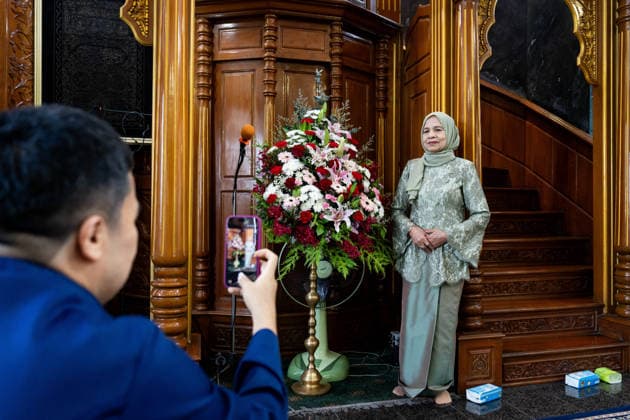 Eid al-Adha in Thailand BANGKOK, THAILAND - MAY 28: A member of the community has their photo taken in front of a bouquet of flowers before praying begins. Thai Muslims pray during Eid al-Adha at Masjid Buddarul Mumineen mosque in Bangkok, Thailand on May 28, 2026. Matt Hunt Anadolu Bangkok Thailand. Editorial use only. Please get in touch for any other usage.  Copyright: x2026xAnadoluxMattxHuntx