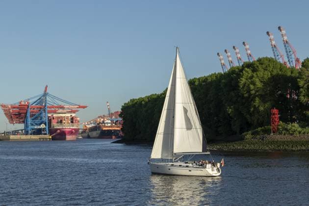 Segelboot im Sommer unterwegs auf der Elbe vor Containerschiffen und Containerbrücken am Containerterminal Burchardkai im Hafen von Hamburg, Deutschland Sailing boat on the Elbe in summer in front of container ships and container bridges at the Burchardkai container terminal in the port of Hamburg, Germany Copyright: imageBROKER ChristopherxTamcke iblcrt17868607.jpg