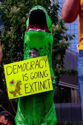 Fight Back Rally in Downtown Edmonton, Canada - 29 May 2026 A protester wearing a costume of the Dancing Dino holds a placard during the demonstration march through the streets of Downtown Edmonton to protest the Actions of the Provincial United Conservative Party Government. Downtown Edmonton Canada Copyright: xRonxPalmerx xSOPAxImagesx 2026_05_29Fightbackrally825059