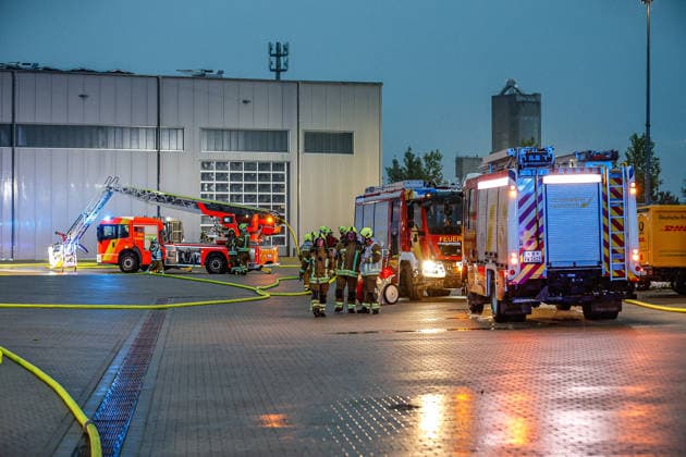 Großbrand in einer Lager- und Logistikhalle Haupteinfahr zur Lagerhalle, Löschfahrzeuge und Drehleiter der Feuerwehr Hannover im Hintergrund Hannover-Anderten Lohweg 7, Gewerbegebiet Niedersachsen, Region Hannover Germany *** Major fire in a warehouse and logistics hall Main entrance to the warehouse, fire engines and turntable ladder of the Hanover fire department in the background Hanover Anderten Lohweg 7, Lower Saxony industrial estate, Hanover region Germany