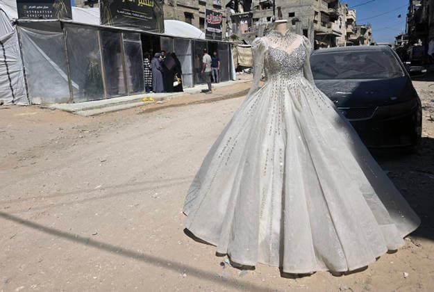 Customers browse wedding attire in Khan Younis despite wartime hardships Customers browse wedding dresses and suits inside a bridal shop in Khan Younis in the southern Gaza Strip on June 1, 2026, as Palestinians continue to uphold marriage traditions despite the ongoing war, widespread destruction, and difficult economic and humanitarian conditions. Shop owners say demand for wedding supplies remains present, though at a lower pace, as many families turn to less costly options amid declining incomes, rising prices, and shortages of goods linked to Israeli restrictions at border crossings. Photo by Tariq Mohammad APA Images Khan Yunis Gaza Strip Palestinian Territory 010626_Khan_Yunis_TM_00(10) Copyright: xapaimagesxTariqxMohammad xapaimagesx