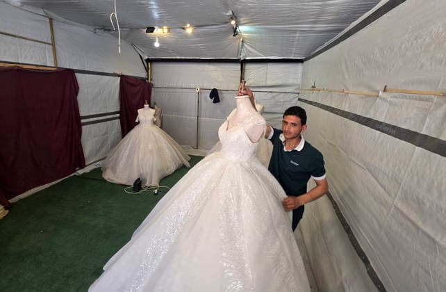 Customers browse wedding attire in Khan Younis despite wartime hardships Customers browse wedding dresses and suits inside a bridal shop in Khan Younis in the southern Gaza Strip on June 1, 2026, as Palestinians continue to uphold marriage traditions despite the ongoing war, widespread destruction, and difficult economic and humanitarian conditions. Shop owners say demand for wedding supplies remains present, though at a lower pace, as many families turn to less costly options amid declining incomes, rising prices, and shortages of goods linked to Israeli restrictions at border crossings. Photo by Tariq Mohammad APA Images Khan Yunis Gaza Strip Palestinian Territory 010626_Khan_Yunis_TM_00(15) Copyright: xapaimagesxTariqxMohammad xapaimagesx