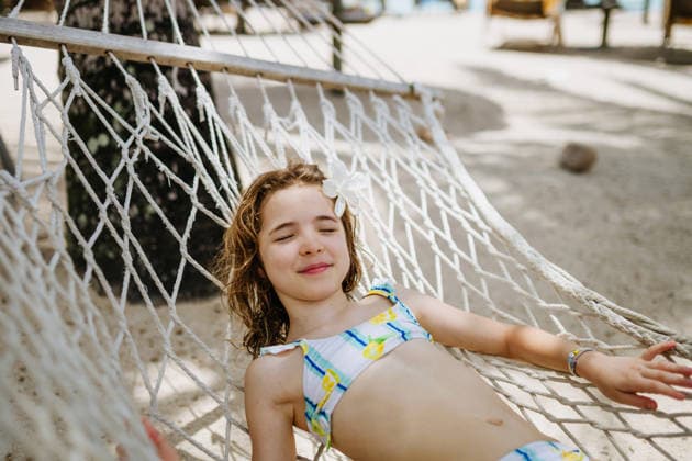 Smiling girl relaxing in hammock during tropical family vacation. Smiling girl relaxing in hammock during tropical family vacation. Summer holiday. model released