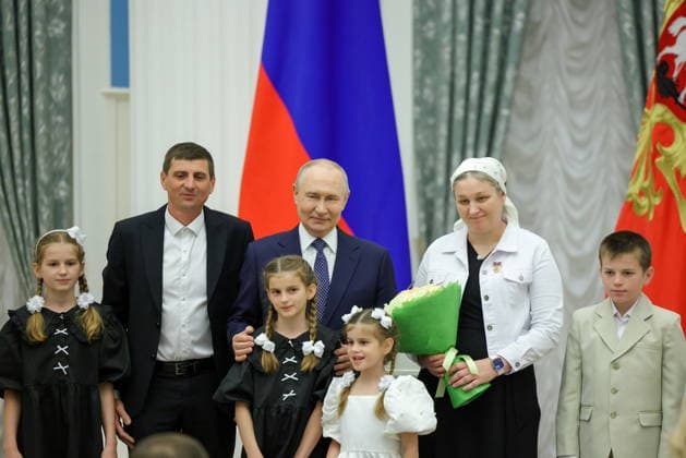 RUSSIA, MOSCOW - JUNE 1, 2026: Russia s President Vladimir Putin (C) and a family pose for a group photograph during a ceremony to present Russia s Orders Mother Heroine and Orders Parental Glory at the Catherine Hall of the Kremlin on World Children s Day. Artyom Geodakyan TASS  93273216