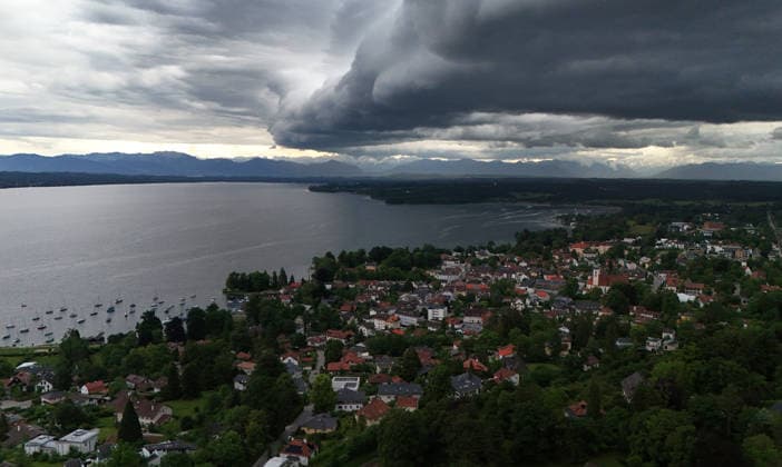 Ein Frühsommertag in Tutzing (Landkreis Starnberg). Hier der Blick über die Ortschaft und den Starnberger See mit der Alpenkette am Horizont, wo gerade ein Unwetter aufzieht, drüberzieht, eine Wolkenwand, Gewitterwalze, Wolkenrolle, Gewitterfront, Gewitterrolle, Unwetterfront, dunkle Wolken, Wetterbild *** An early summer day in Tutzing, Starnberg district Here the view over the village and Lake Starnberg with the Alps on the horizon, where a thunderstorm is just coming up, a wall of clouds, thunderstorm roll, cloud roll, thunderstorm front, thunderstorm roll, thunderstorm front, dark clouds, weather picture