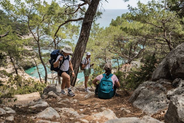 Three women hiking on a scenic trail by the sea Kemer, Antalya, Türkiye CR_BMEE260528EF-2037245-01 ,model released, Symbolfoto