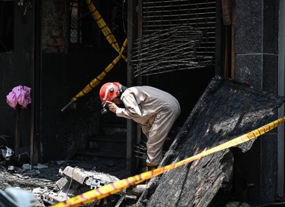 NEW DELHI, INDIA - JUNE 3: Firefighters and rescue personnel conduct rescue and recovery operations after a massive fire broke out in a five-storey building housing a restaurant and bed-and-breakfast guest accommodation in the highly congested Hauz Rani area of Malviya Nagar on June 3, 2026 in New Delhi, India. The blaze at the Flourish Stay B&B and Lemon Green Restaurant started around 8.30 am and quickly spread, catching everybody unawares. Rescue workers, including many locals, rushed to the spot to pull out those trapped inside the five-floor narrow building. About 40 people were rescued and rushed to hospital where 21 were declared brought dead, officials said. The death toll could rise with several of the injured in a critical conditi