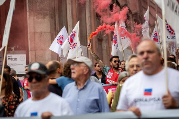 National General Strike in Porto, Portugal - 03 Jun 2026 A protester raises a red flare as demonstrators gather during the national general strike. Demonstrators gathered at Praça da Batalha and Avenida dos Aliados for a national general strike. Union groups, workers and supporters marched with banners, flags and handwritten signs criticizing the government’s proposed labour reforms and calling for improved working conditions, higher wages and stronger public services. The protest featured megaphones, flares and visual messages reflecting broad mobilization across the city. Porto Portugal Copyright: xDiogoxBaptistax xSOPAxImagesx DB_20260603GREVEGERALPORTO_0015