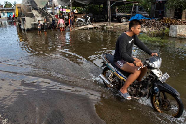 World Tidal Crisis - Indonesia A motorcycle navigates through a tidal flood in Kecamatan Medan Belawan, Medan, North Sumatra, Indonesia, on June 03, 2026. This localized inundation aligns with data from UN Climate Change, which warns that rising global sea levels are increasingly threatening low-lying coastal zones and displacing communities across multiple continents. Photo by Aditya Sutanta ABACAPRESS.COM Indonesia  Copyright: xAdityaxSutanta ABACAx