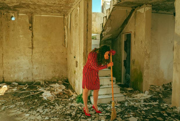 Exhausted cleaner resting on broom in a ruined building model released, Symbolfoto, AAF00567