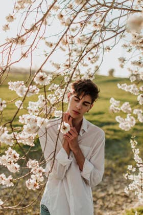 Portrait in a spring meadow among blooming tree branches model released, Symbolfoto, GMLF01740