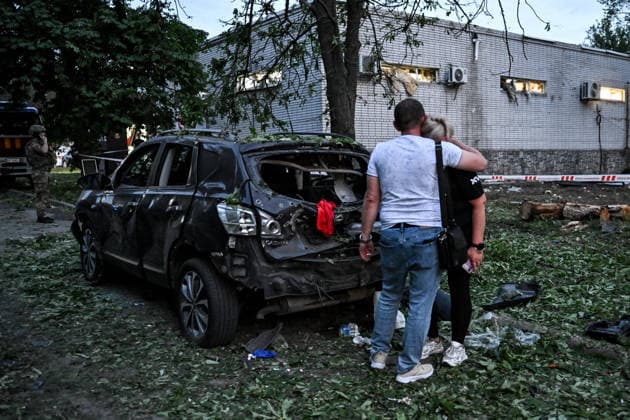 A man embraces a woman by a car, destroyed by a Russian drone attack in a residential area in the Shevchenkivskyi district of Zaporizhzhia, Ukraine, June 4, 2026. Russian forces launched a drone strike on one of the city’s residential areas, killing one person and injuring 16 others. The blast wave and debris shattered windows and balconies in apartment blocks. (Photo by Dmytro Smolienko Ukrinform) Russian forces launch drone strike on district in Zaporizhzhia  Copyright: xDmytroxSmolienkox