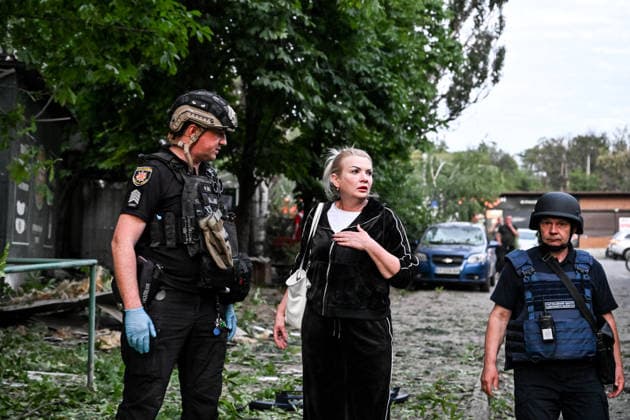 Law enforcers flag a woman during a response effort to a Russian drone attack on a residential area in the Shevchenkivskyi district, Zaporizhzhia, Ukraine, June 4, 2026. Russian forces launched a drone strike on one of the city’s residential areas, killing one person and injuring 16 others. The blast wave and debris shattered windows and balconies in apartment blocks. (Photo by Dmytro Smolienko Ukrinform) Russian forces launch drone strike on district in Zaporizhzhia  Copyright: xDmytroxSmolienkox