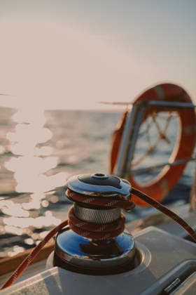 Sailboat winch with red rope on deck at sunset property released, GMLF01889