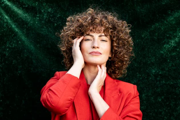Portrait of model with curly hair and blazer posing in a garden model released, Symbolfoto property released, LMCF02884