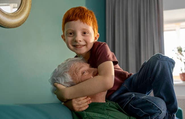 Smiling grandson with red hair hugging grandfather at home model released, Symbolfoto property released, MBLF01242