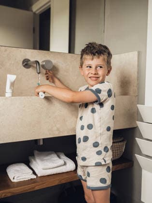 Smiling boy brushing teeth at modern bathroom sink model released, Symbolfoto, MFF10101
