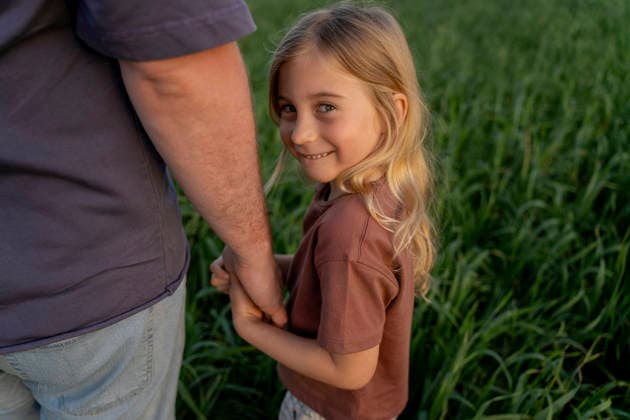Father and daughter holding hands in green field smiling model released, Symbolfoto, OGSF00315
