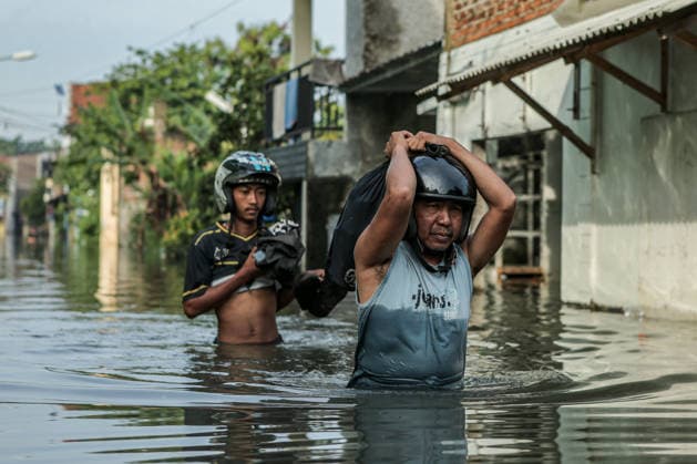 BANDUNG REGENCY, WEST JAVA PROVINCE, INDONESIA - MAY 26, 2026: People wade through floodwaters. Flooding that began on May 24, 2026, caused by the overflowing of the Citarum River following heavy rains, has affected several areas in the regency, including Dayeuhkolot and Bojongsoang, with water levels reaching 20 200 cm. Bandung Regency West Java Indonesia Copyright: xClaudioxPramanax