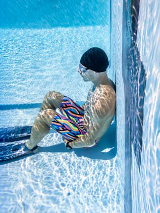Athlete sitting underwater in a swimming pool wearing swimwear model released, Symbolfoto, STSF04067