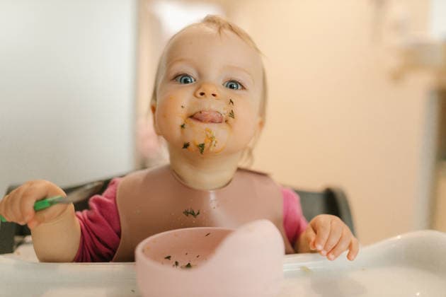 Messy eater holding spoon in highchair indoors model released, Symbolfoto property released, VIVF01811