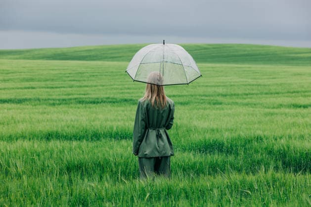Woman standing in green wheat field with transparent umbrella in the rain model released, Symbolfoto, VSNF04975