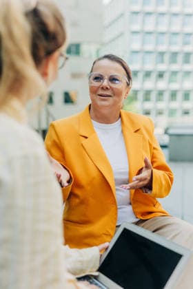 Female manager discussing business strategy outdoors with colleague model released, Symbolfoto, VSNF04998
