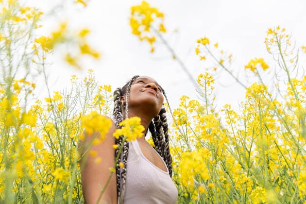 Person with braids enjoying peace in a yellow rapeseed field model released, Symbolfoto, YPF00295