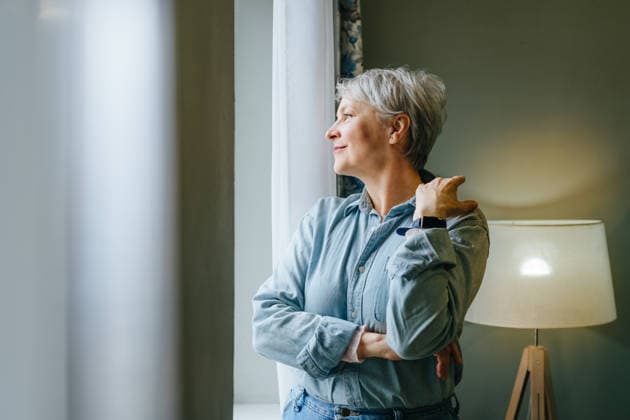 Smiling woman with grey hair indoors looking out window model released, Symbolfoto property released, YTF04891