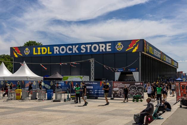 Musikfestival Rock im Park 2026 - Lidl Rock Store, Nürnberg, 06.06.2026 Der Lidl Rock Store als Versorgungseinrichtung auf dem Festivalgelaende von Rock im Park. Besucher und Mitarbeiter bewegen sich vor dem markant beschrifteten Veranstaltungspavillon. Nürnberg Bayern Deutschland *** Music festival Rock im Park 2026 Lidl Rock Store, Nuremberg, 06 06 2026 The Lidl Rock Store as a supply facility on the festival grounds of Rock im Park Visitors and employees move in front of the strikingly labeled event pavilion Nuremberg Bavaria Germany 20260606-286A8120-M4000